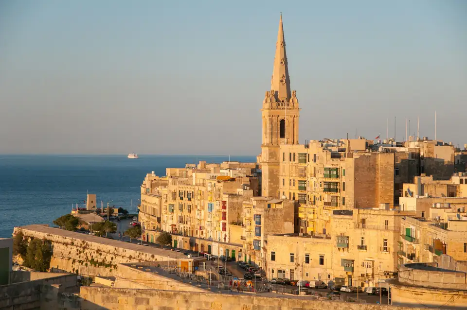 Valletta ao pôr do sol, com a cúpula e as torres sobre o mar
